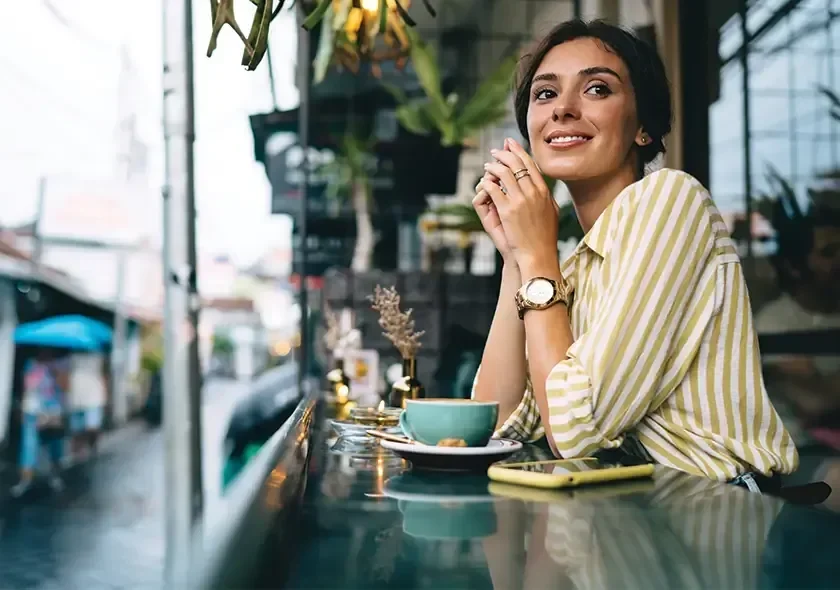 Smiling Teachers member enjoying a coffee at a café.